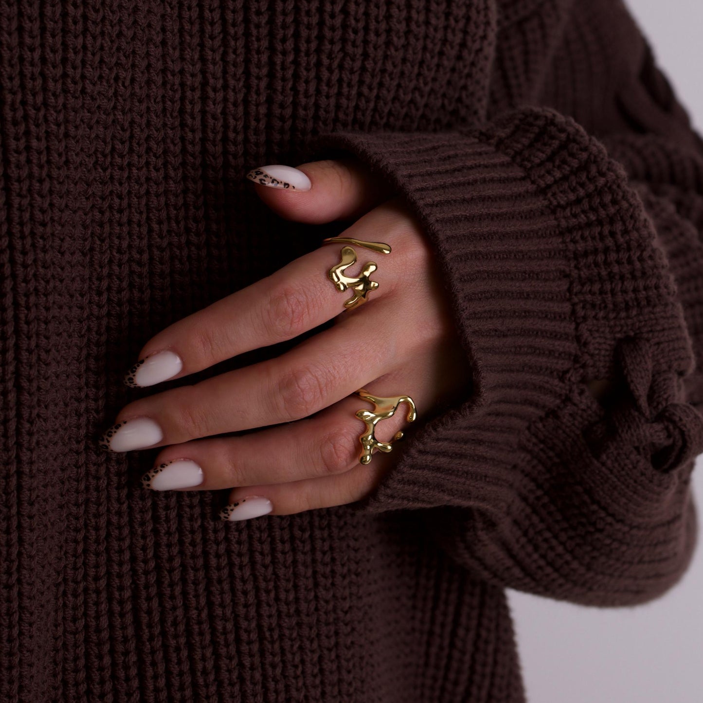 women hand wearing gold rings