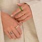 Close-up of hands wearing rings with a neutral background
