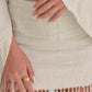 Close-up of a person wearing a beige skirt with fringe details.