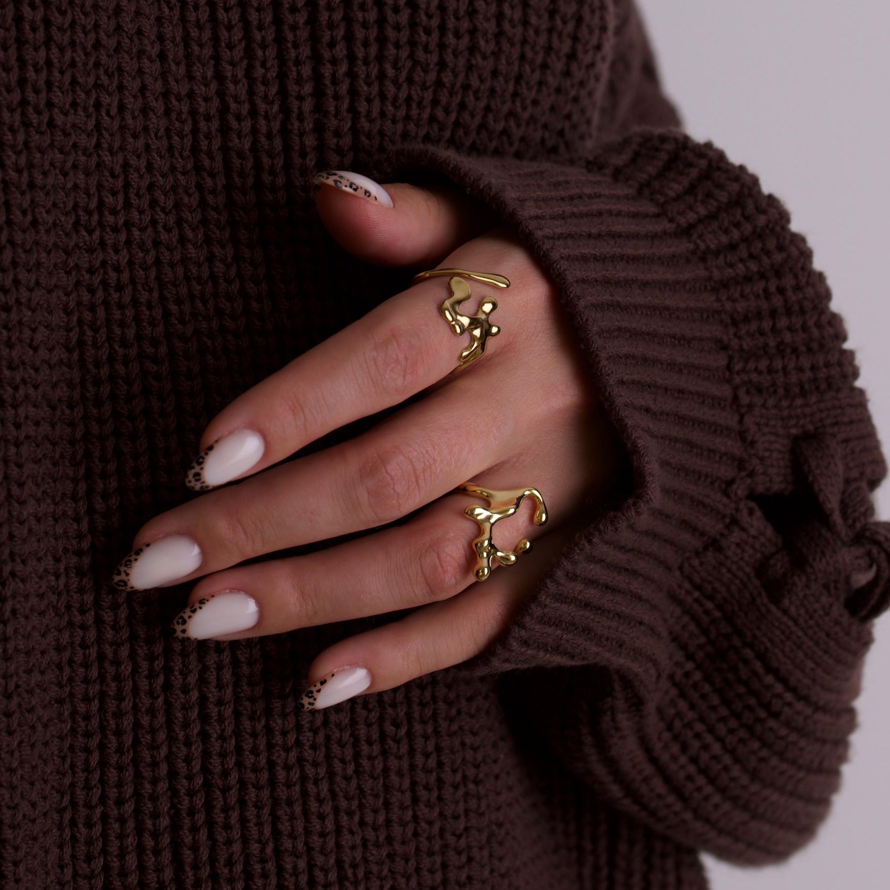 Women hand wearing gold rings