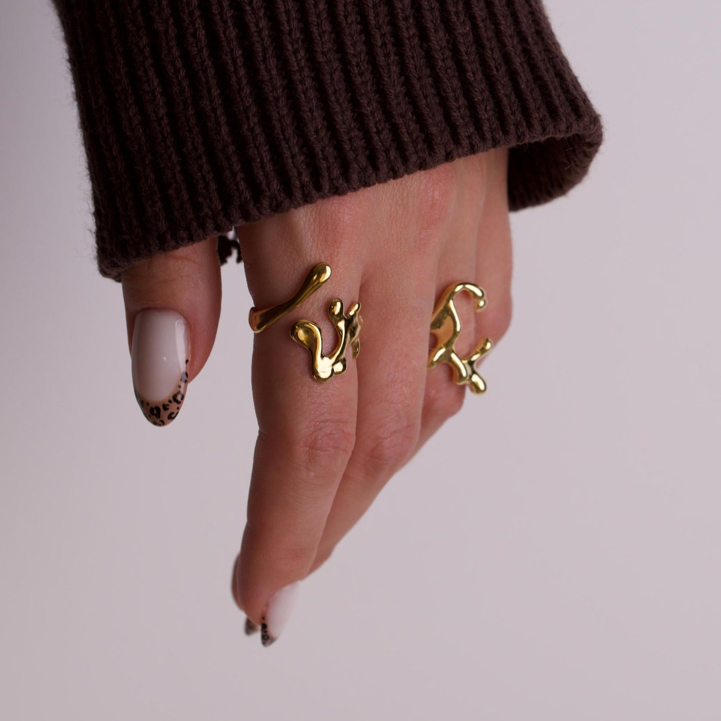 Women hand wearing gold rings